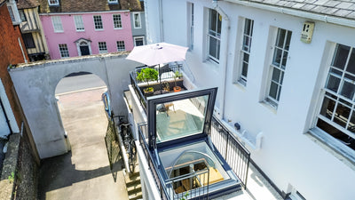door-style rooflight open on a roof terrace with a white building to the right