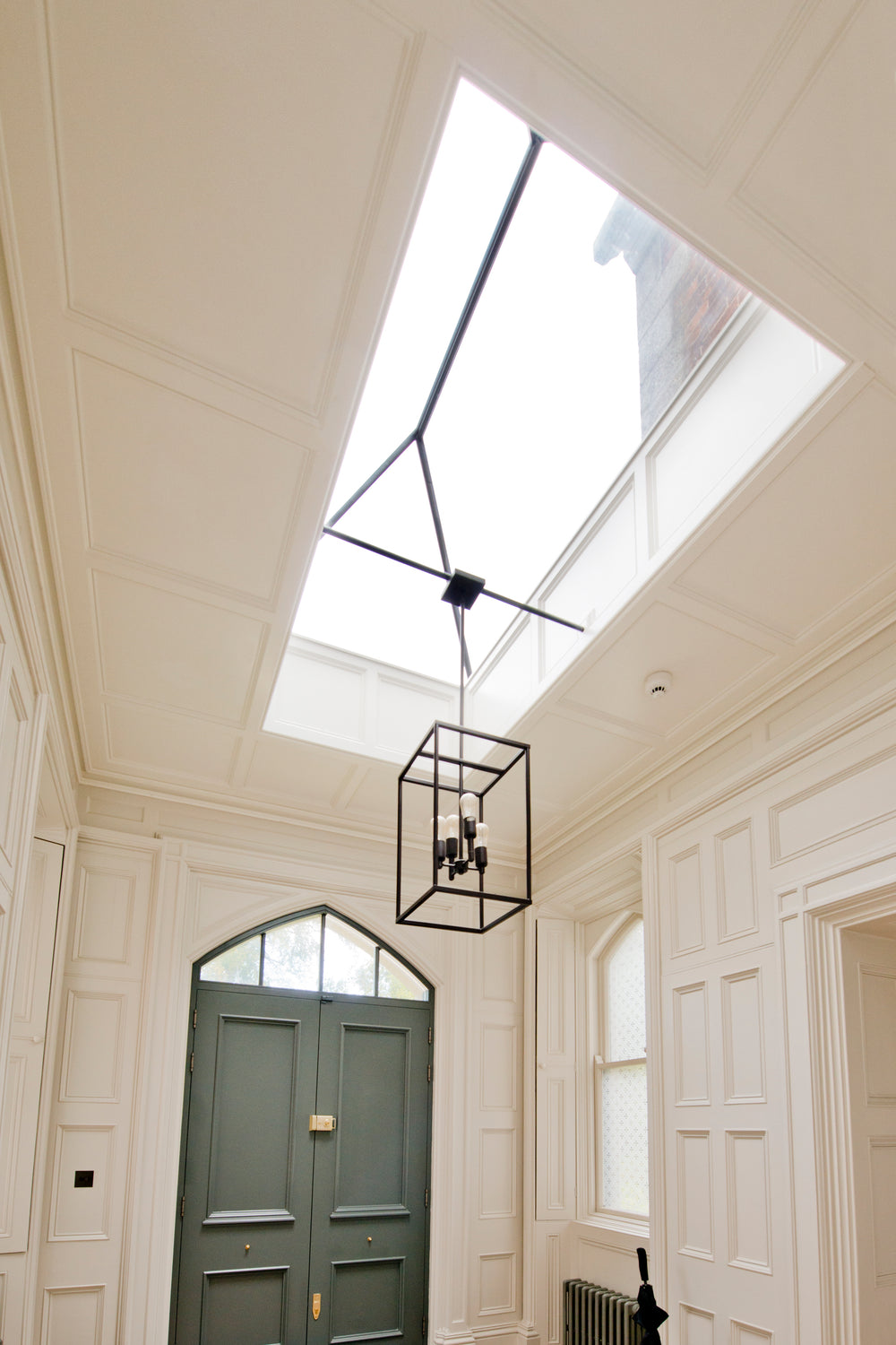 a roof lantern (seen from below) installed in a white hallway with a sage green door