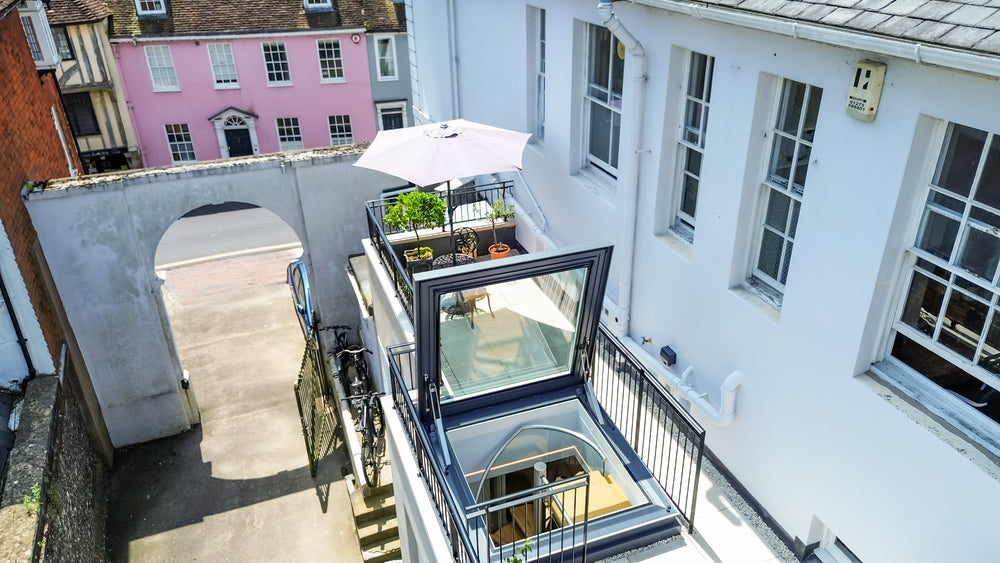 door-style rooflight open on a roof terrace with a white building to the right