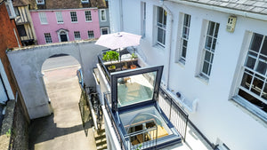 door-style rooflight open on a roof terrace with a white building to the right