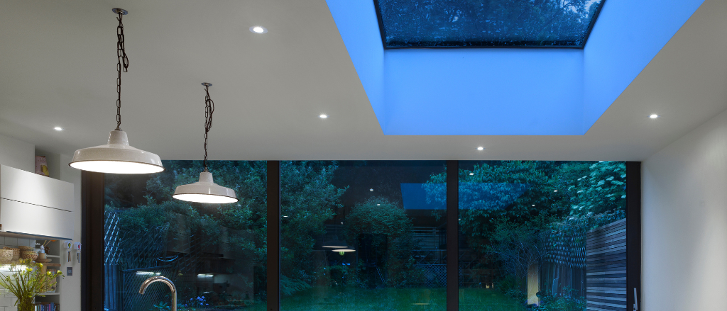 Night time photograph of Glazing Vision Flushglaze rooflight in kitchen with kitchen table and a kitchen counter to the left